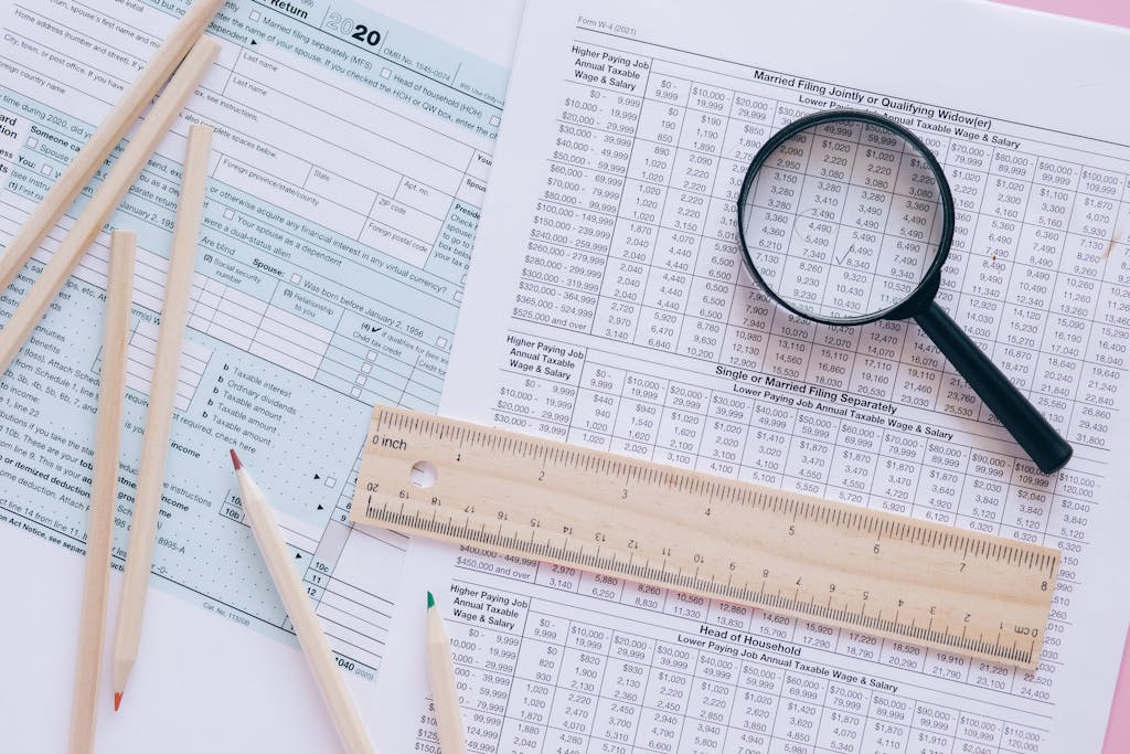 A high angle view showing IRS tax forms with pencils, ruler, and magnifying glass for financial planning.