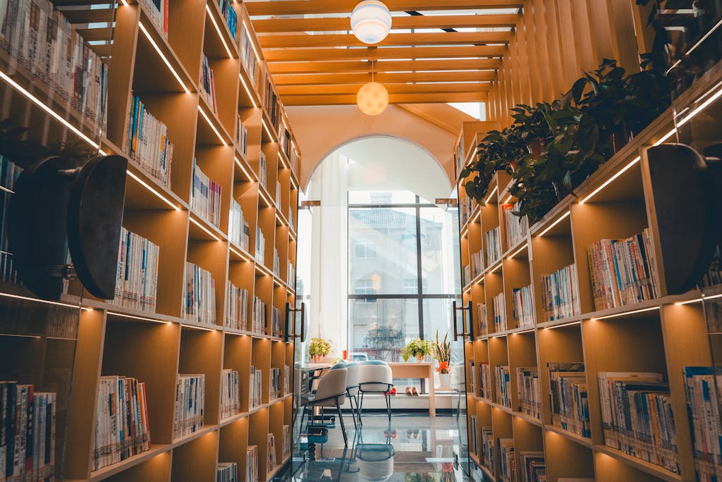 A modern library interior with illuminated wooden shelves and reading area.